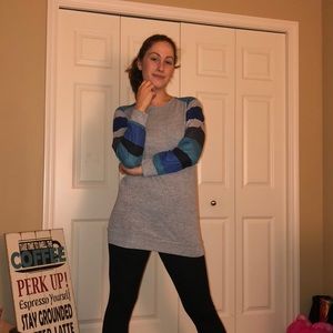 grey tunic with striped sleeves and black leggings